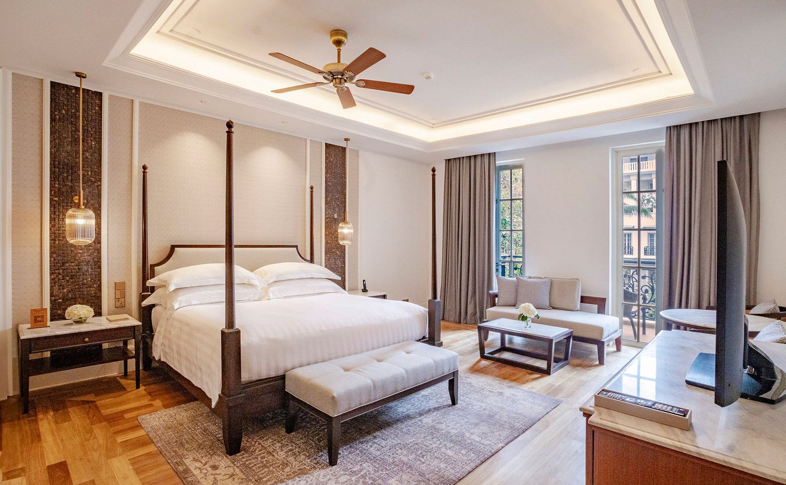 Colonial-style hotel suite with four-poster bed, coffered ceiling and balcony doors