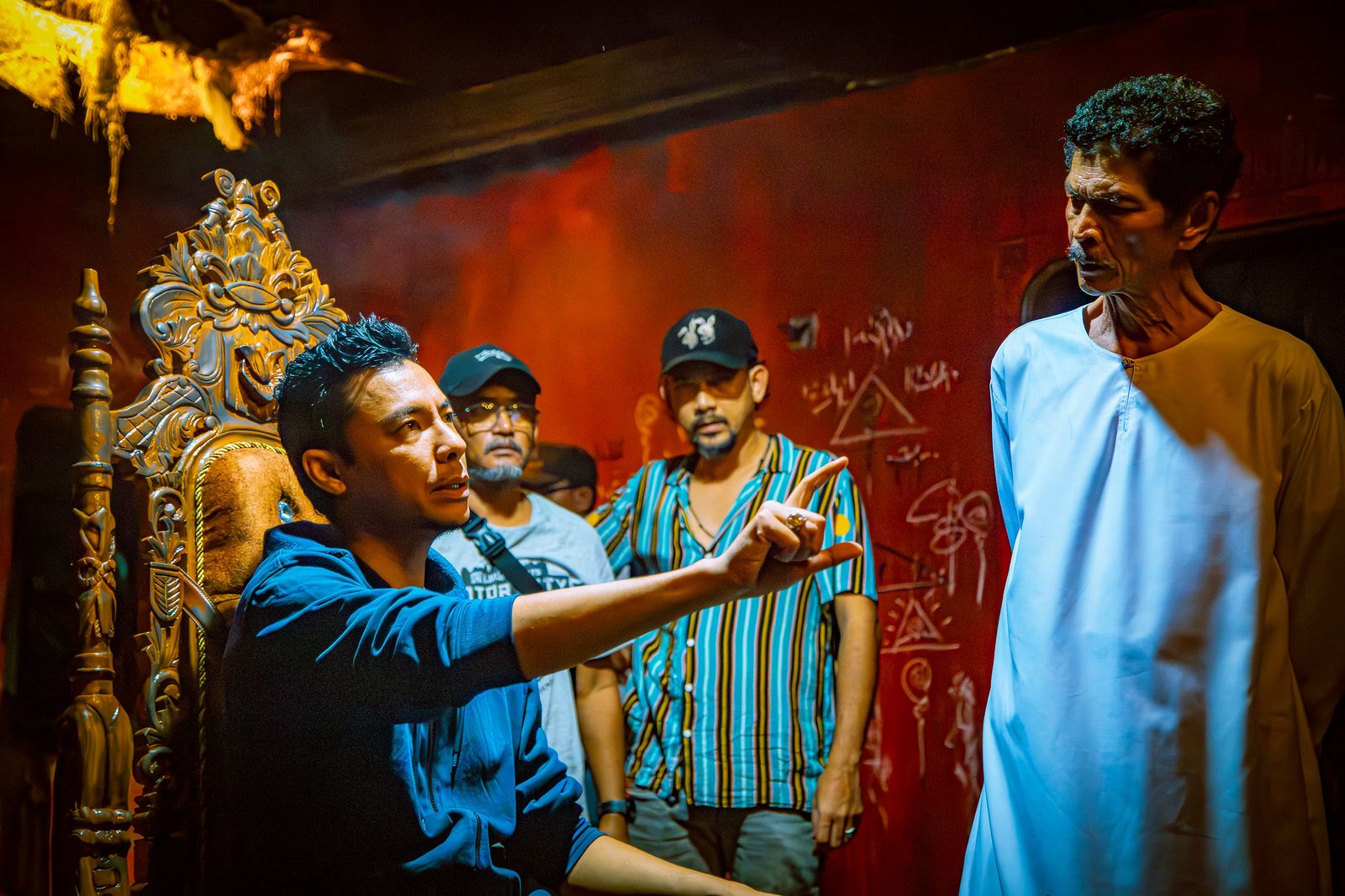 Director giving direction to an actor on a red-lit set