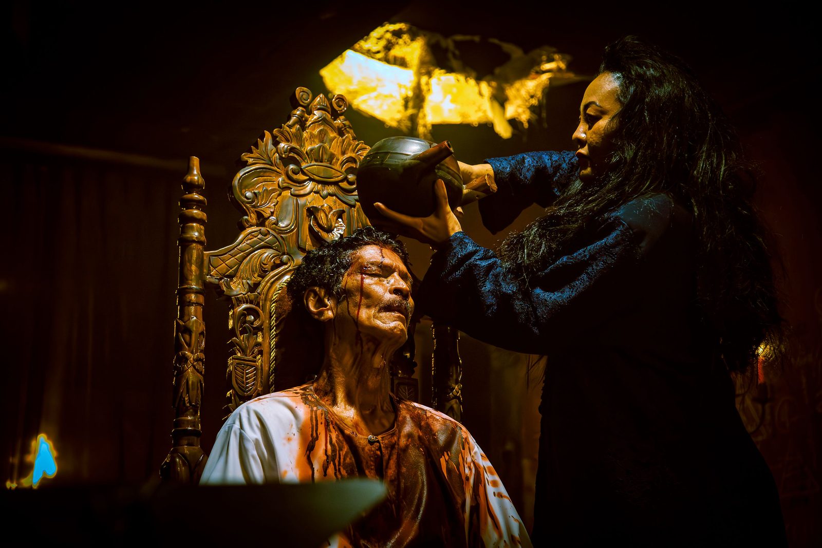 Makeup artist applying prosthetic effects to an actor on set