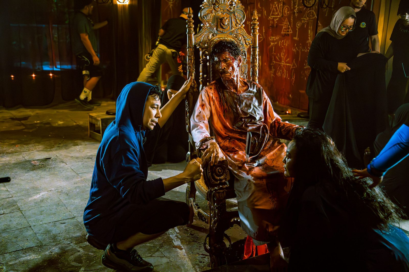 Crew adjusting an actor's costume between takes