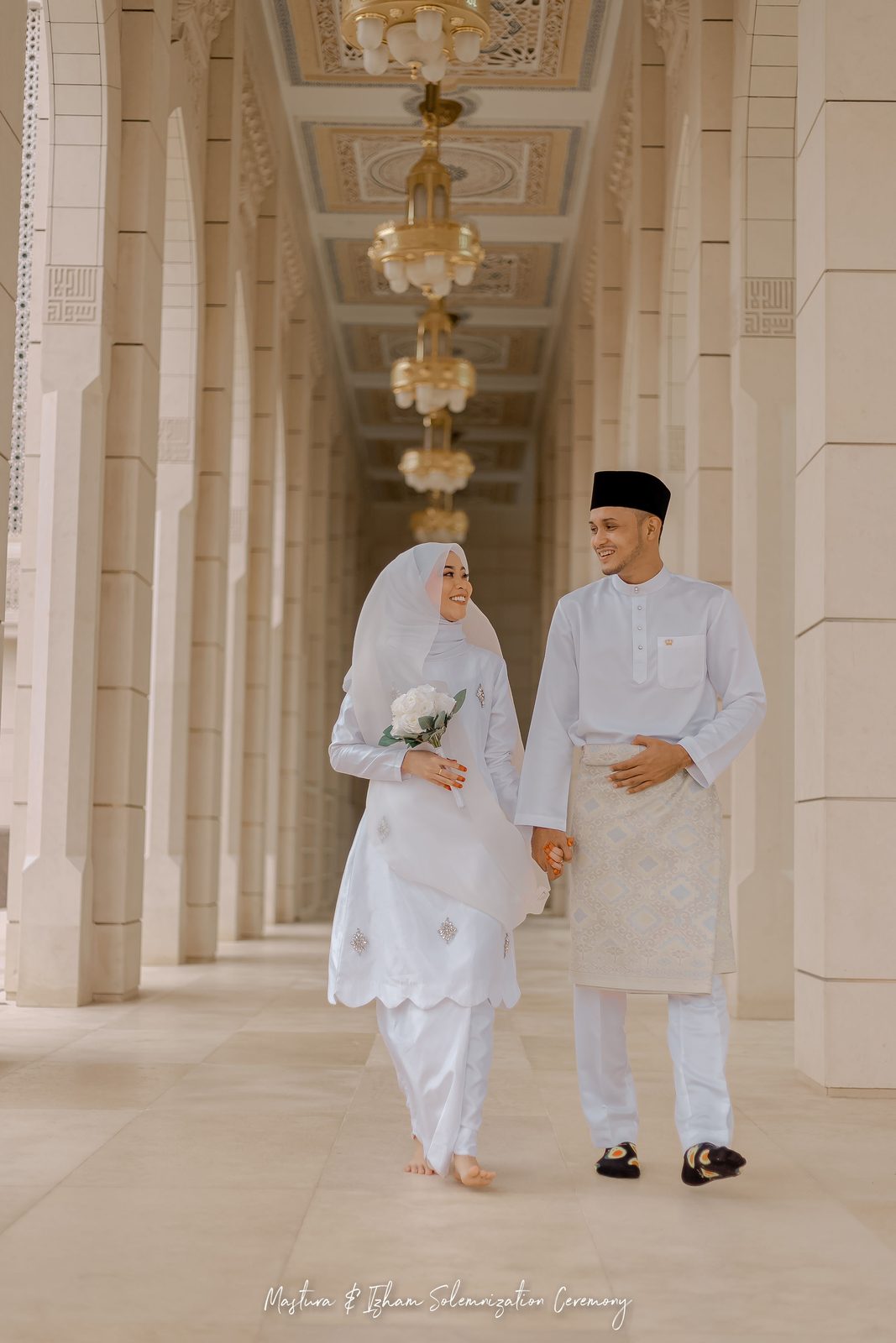 Couple walking through a white marble colonnade